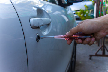 Selective focus on car key remote and tools in man's hand open the car door. life concept.Close-up