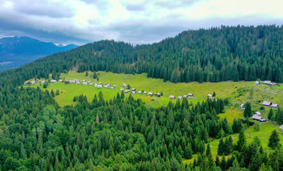 Aerial image of Planina Zajamniki empty Shepherd village houses surrounded by lush green nature.