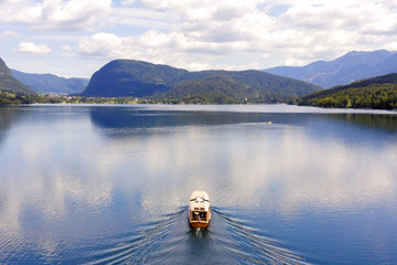 Aerial image of a small Tourist Boat sailing slowly at Lake Bohinj, Slovenia