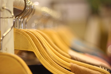 clothing on​ wooden​ hanger​ at​ night​ market.​ Sensitive focus​ the​ wood​en​ hanger.​blur​ hanger​ background.