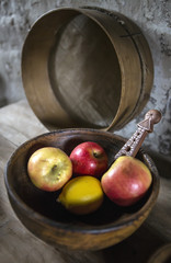 Apples and lemon in vintage wooden bowl still life.