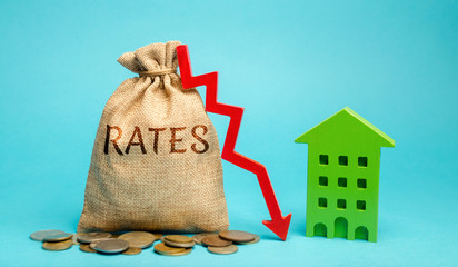 Money bag with the word Rates, down arrow and wooden house. The concept of reducing interest rates...
