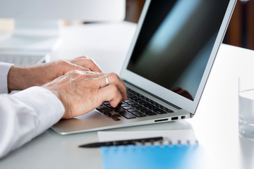Closeup of businessman's hands working with laptop