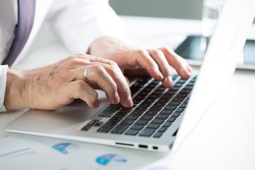 Fototapeta na wymiar Closeup of businessman's hands working with laptop
