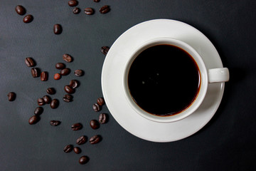 Black coffee, Americano coffee in a white cup with coffee beans on black background.