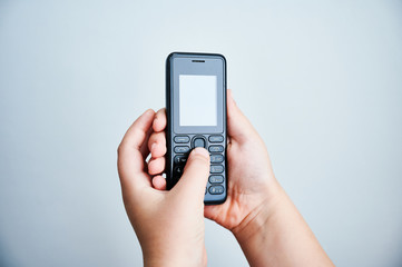 Child holding a traditional mobile phone on white backround