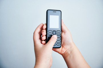 Child holding a traditional mobile phone on white backround