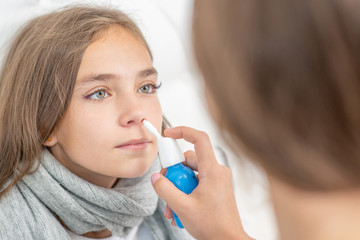 Woman using nose spray to cure her teen girl at home