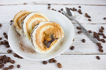 Cup of coffee on a white wooden table and a cake