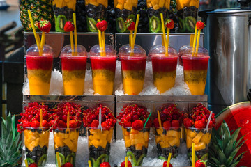 Fototapeta premium Multifruit set. Chilled glass with kiwi, pineapple, grapes, strawberries, berries. beautifully served desserts for tourists. ice and spoons. delicious stand healthy summer treats rich in vitamins