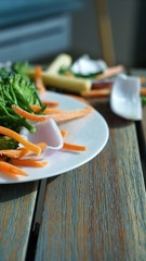 fresh salad at plate with wooden background