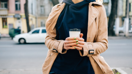 Paper cup of coffee in female hands