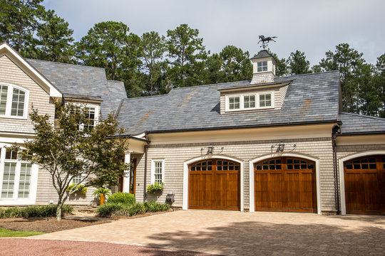 Stained Wood Triple Custom Garage Doors For Large Southern Home With Curb Appeal