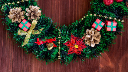Fototapeta na wymiar Christmas wreath with toys decorates the door of the house.
