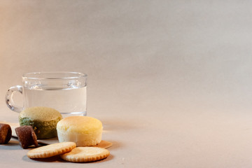 Cheese cakes, sugarcane and crackers with a cup of water on paper. Sweetmeat concept. Macha flavor.