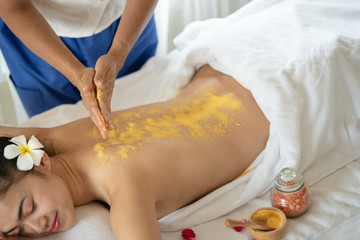 Obraz na płótnie Canvas Beautiful Asian woman having exfoliation treatment with body scrub in spa salon, scrubbing and skin care concept, enjoying and relaxing time