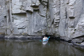 Deurstickers Canoe with people aboard going inside of a cave of rocks. Buksky canyon, Ukraine © Yurii Zushchyk