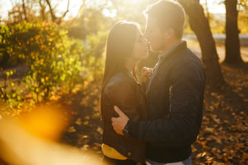 Lovely beautiful couple enjoying each other.  Beautiful autumn day. Lifestyle, happy couple of two play on a sunny day in the park. The concept of youth, love and lifestyle.