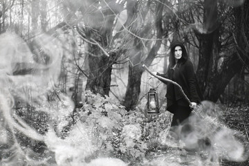 Fototapeta premium Woman in a witch suit in a dense forest