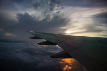 Naklejka na ściany i meble Airplane wing in the sky at sunset