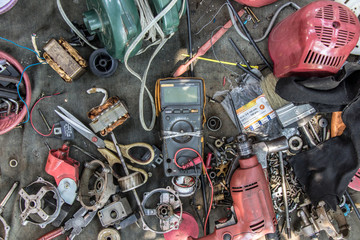 Workshop desktop of electrician repairman. Clutter on a desk full of appliances and components for...