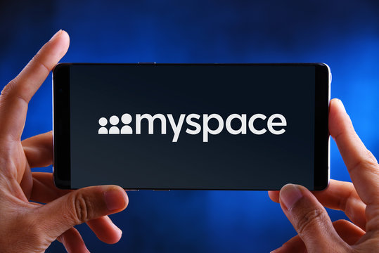 Hands holding smartphone displaying logo of Myspace