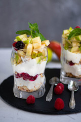 Curd dessert. Made from apples, pears, cookies, decorated with mint and blackberry. Diet. Near apples, pears, pomegranates, grapes, lime. Near glasses of raspberries. Healthy eating Light breakfast. 