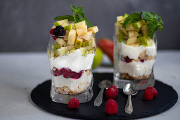 Curd dessert. Made from apples, pears, cookies, decorated with mint and blackberry. Diet. Near apples, pears, pomegranates, grapes, lime. Near glasses of raspberries. Healthy eating Light breakfast. 