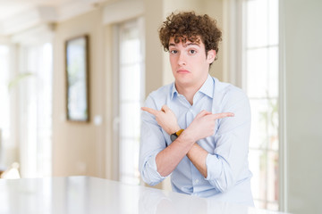 Young business man with curly read head Pointing to both sides with fingers, different direction...