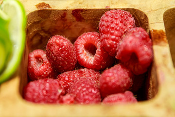 Raspberries in a wooden bowl ready to be used in a cocktail