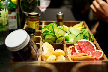 Lemons, tangerines, grapefruit, cucumbers and spices in a wooden bowl ready to be used in a cocktail