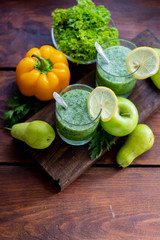 Diet drink, smoothie. Green color. Body cleansing. Diet. Nearby are orange pumpkin, pears, apple, mint leaves, pepper. Lobules of Lemon. A bunch of white grapes. Healthy eating Light breakfast. 