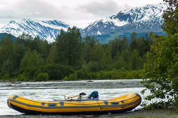Rafts on river with snow-capped mountains in background