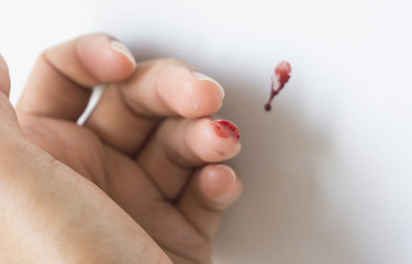Red blood from finger on white background..