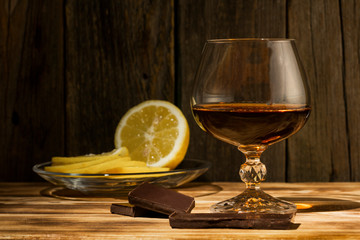 glass with cognac close-up on an old wooden background
