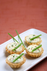 Mini cheese tartlets, presentation of catering for celebration. Served on colored tablecloth.