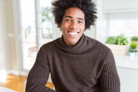 African American man wearing winter sweater with a happy and cool smile on face. Lucky person.