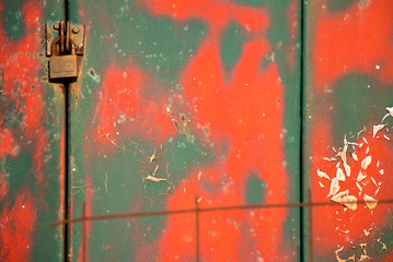 Weathered vibrant  layered green and red cracked paint on metal