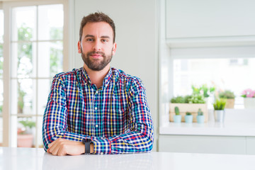 Handsome man wearing colorful shirt with serious expression on face. Simple and natural looking at...