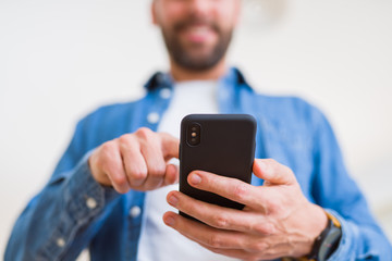 Close up of man hands using smartphone and smiling