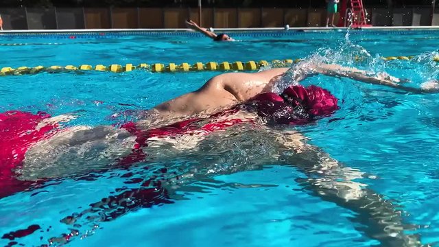 Woman swims in crawl in pool outdoors. Professional athlete freestyle training