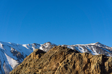 Scene view of mountain climbers reaching mountain peak against snow-capped Andes mountains in...