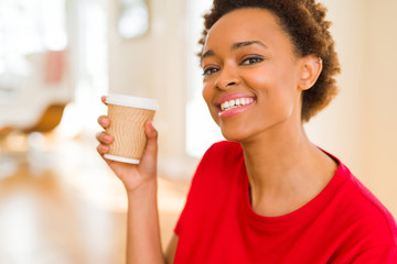 Beautiful young african american woman drinking a coffee in a take away paper cup