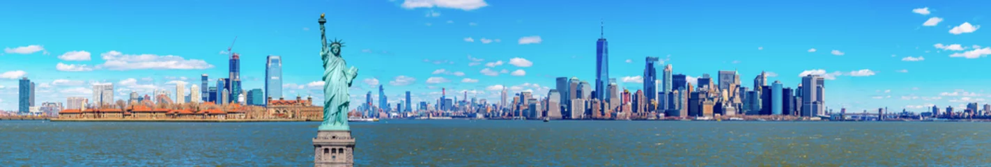 Fototapeten Panorama of The Statue of Liberty with the One world Trade building center over hudson river and New York cityscape background, Landmarks of lower manhattan New York city. © ChayTee