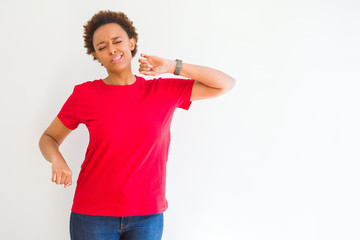 Young beautiful african american woman over white background stretching back, tired and relaxed,...