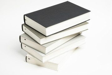 A Disarrayed Stack OF Monochromatic Cloth Bound Books Set On  White Background