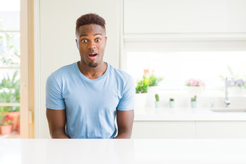 Handsome african american man wearing casual t-shirt at home afraid and shocked with surprise...