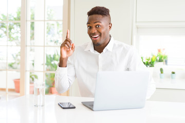 Fototapeta premium African american business man working using laptop pointing finger up with successful idea. Exited and happy. Number one.