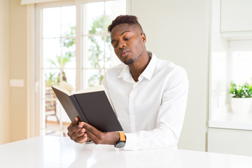 Young african man reading a book, studying for univeristy