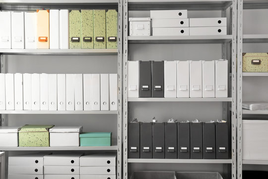 Folders with documents on shelves in archive